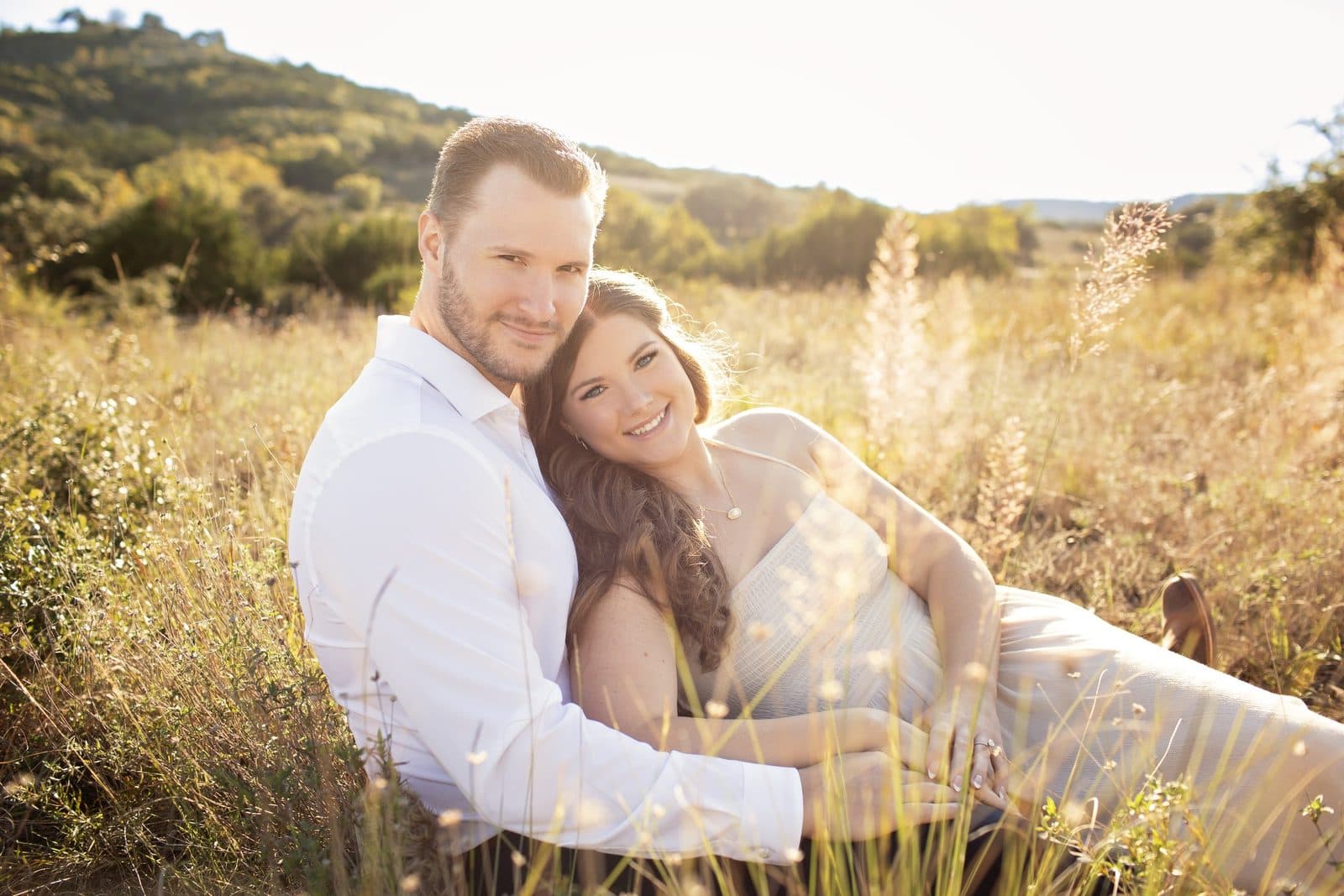 The husband-and-wife owners of Trailer Bash Events together in a Texas Hill Country field at sunset